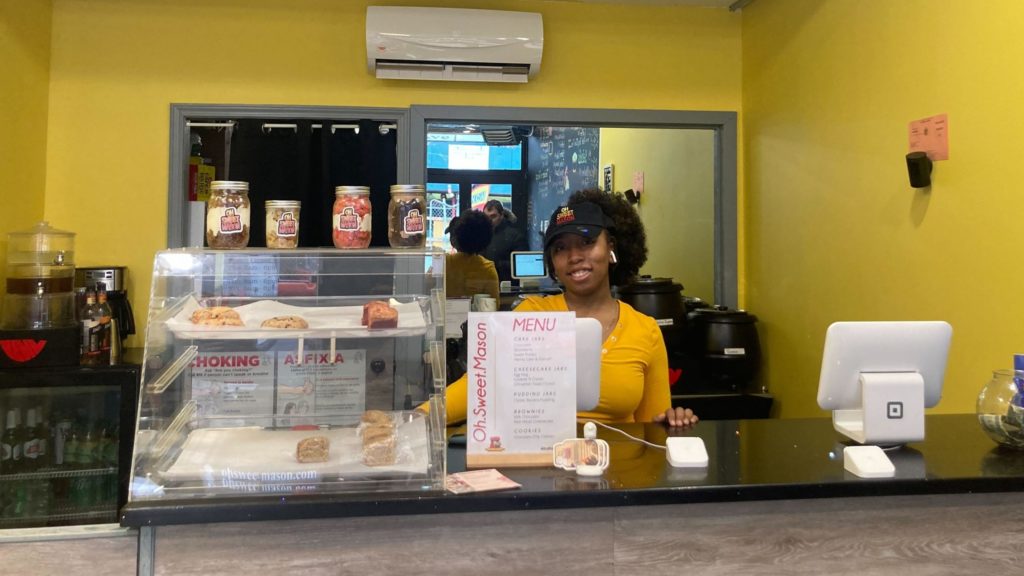Female entrepreneur standing behind the counter at her bakery